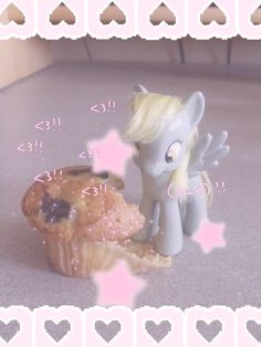 a little pony next to a muffin on a counter