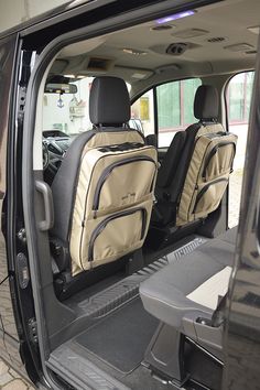 the back seats of a vehicle with luggage in it's cargo compartment and side door open