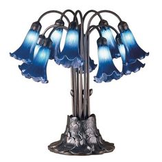 a blue glass lamp with five flowers on it's base and four lights in the middle