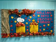 a bulletin board decorated with fall leaves and a snoop bear in a basket reading falling into second grade