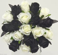 a bouquet of white and black roses in a vase