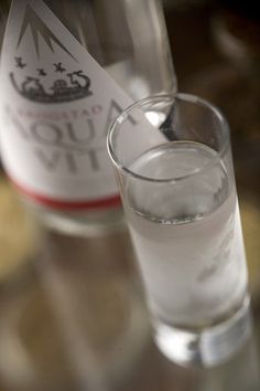 a glass filled with water next to a bottle