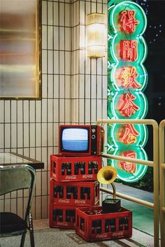 three red boxes stacked on top of each other in front of a neon sign with chinese writing