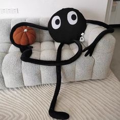 a black and white couch with a pumpkin sitting on it's back legs in the shape of a cartoon character