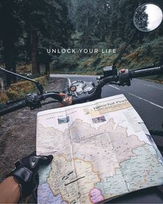 a person on a motorcycle looking at a map with the caption unlock your life