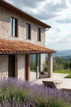 an outside view of a house with lavender in the foreground