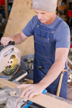 a man using a circular saw to cut wood