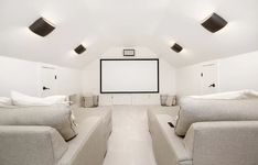 an empty room with couches and a projector screen