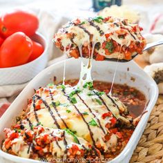 two scoops of lasagna being lifted from a casserole dish