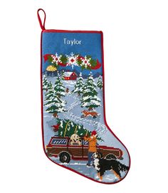 an embroidered christmas stocking with dogs and trees in the snow, on a white background