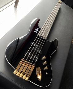 a black bass guitar sitting on top of a table