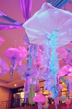 some pink and purple jellyfish hanging from the ceiling in a room with other decorations