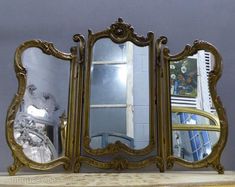 an ornately decorated mirror sits on top of a shelf