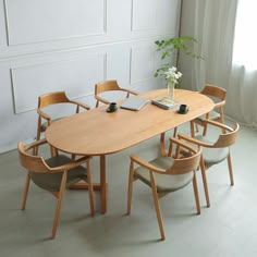 a wooden table with chairs around it and a laptop on the table next to it