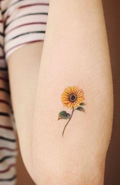 a small sunflower tattoo on the arm