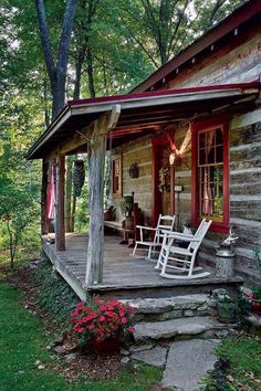 a porch with rocking chairs on it in front of a log cabin