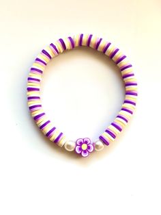 a purple and white bracelet with flowers on it