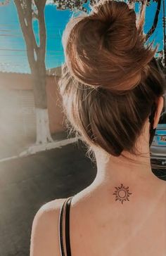 a woman with a sun tattoo on her back neck