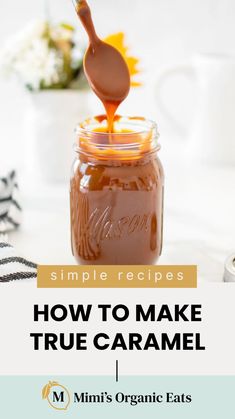 a jar filled with caramel sauce on top of a table next to a spoon