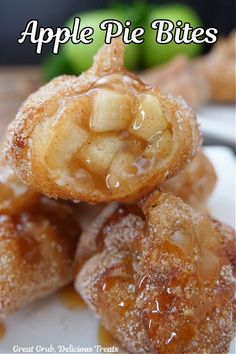 Apple pie bites covered in cinnamon and sugar stacked in a pile with a bite taken out of the top one.