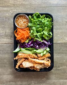 a plastic container filled with salad and meat