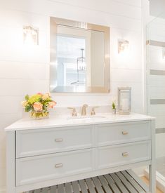 a white bathroom with two sinks and a large mirror over it's sink area