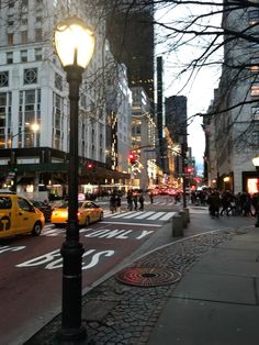 a busy city street filled with lots of traffic next to tall buildings at night time