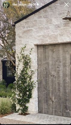 an old white brick building with a wooden door