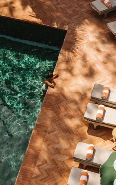 an empty swimming pool surrounded by lounge chairs