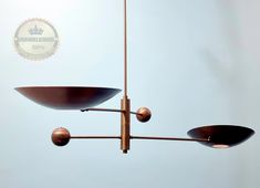 three lights hanging from a metal pole in the air