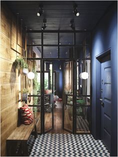 an entry way with black and white checkered flooring, wooden walls and glass doors