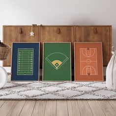 there are three framed sports prints on the floor in front of a dresser and basket