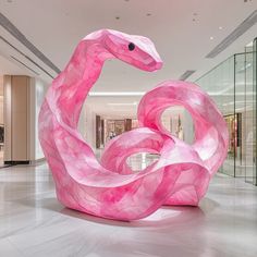 a large pink sculpture in the middle of a mall