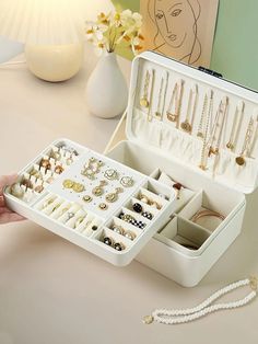 a white jewelry box filled with lots of necklaces