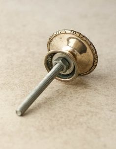 a close up of a metal object with a screw in it's center on the floor