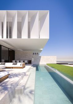 an empty swimming pool in front of a large white building