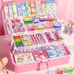 a pink case filled with lots of different types of candy and candies on top of a table