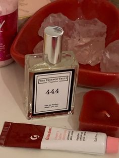 a bottle of perfume sitting on top of a table next to some ice cubes