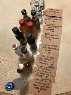 several bottles of alcohol sitting on top of a table next to tags with words written on them