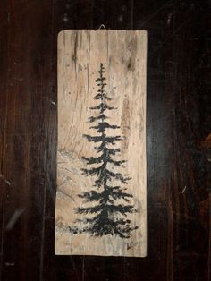 a piece of wood with a tree painted on it's side and black ink