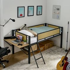 a bedroom with a bed, desk and guitar