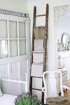 an old ladder leaning up against the wall in a room with white furniture and decor