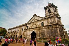 people are walking around in front of an old church