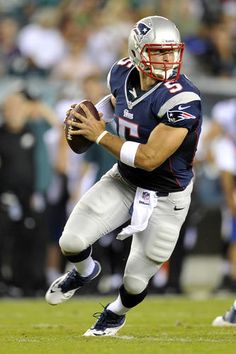 a football player running with the ball in his hand and people watching from the stands