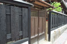 a wooden gate is open on the side of a building