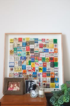 a wooden table topped with a framed photo next to a potted plant