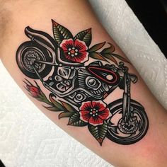 a tattoo with a motorcycle and flowers on it