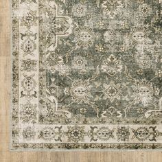 an antique rug with green and beige colors