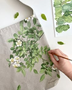 someone is painting flowers on a piece of fabric