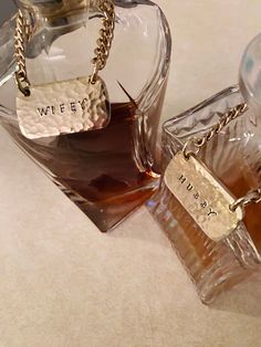 two glass bottles filled with liquid on top of a table